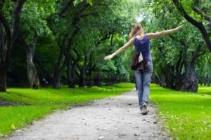 7888887-woman-walking-on-path-in-green-summer-park