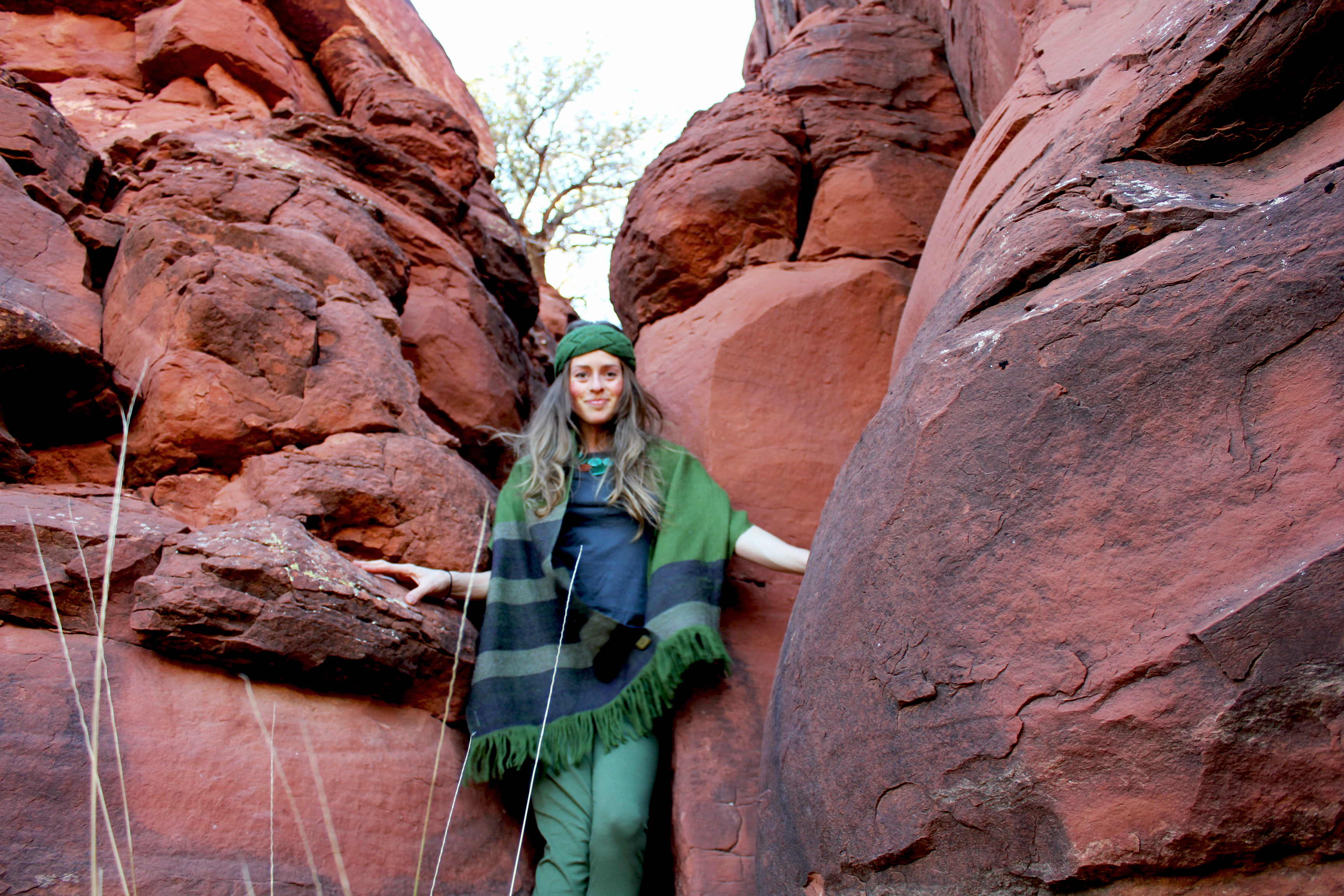 Girl in red rocks with eco-green outfit