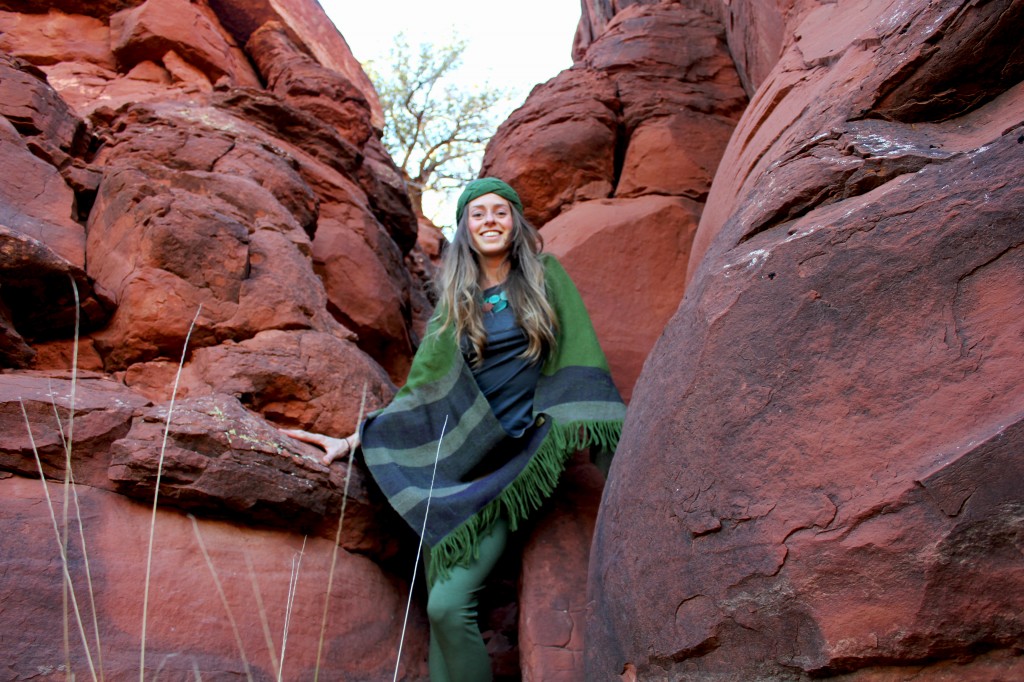 Girl in red rocks in green eco-clothing